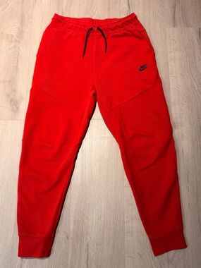 Red Nike tech pants